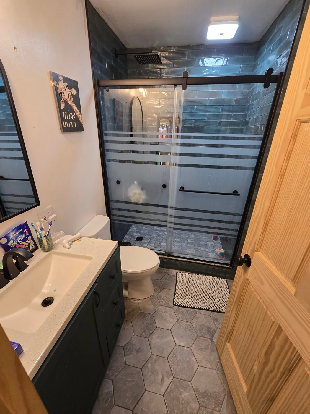 Doug’s remodeled bathroom, with blue shower tile and sliding glass doors