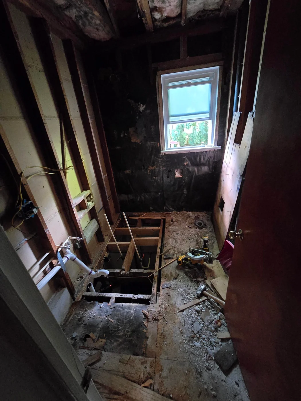 Doug’s bathroom during demolition, with the wall and floor framing exposed